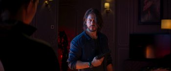 Movie still from “Pathaan” (2023), directed by Siddharth Anand – A man holding a gun while standing in a room; Medium shot, Over the shoulder angle