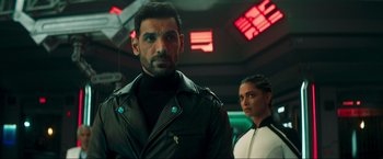 Movie still from “Pathaan” (2023), directed by Siddharth Anand – A man and a woman standing next to each other; Close Up shot, Low angle