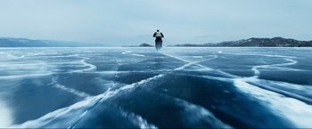 Movie still from “Pathaan” (2023), directed by Siddharth Anand – A man standing on top of a body of water; Extreme Wide shot, High angle