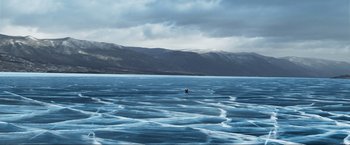 Movie still from “Pathaan” (2023), directed by Siddharth Anand – Two people in a body of water with mountains in the background; Extreme Wide shot, High angle