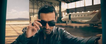 Movie still from “Pathaan” (2023), directed by Siddharth Anand – A person wearing sunglasses; Close Up shot, Low angle