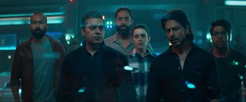 Movie still from “Pathaan” (2023), directed by Siddharth Anand – A group of men standing next to each other in a room; Medium shot, Low angle