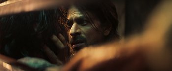 Movie still from “Pathaan” (2023), directed by Siddharth Anand – A person with long hair and a beard; Extreme Close Up shot, Over the shoulder angle