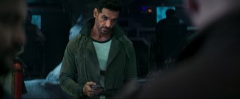 Movie still from “Pathaan” (2023), directed by Siddharth Anand – A person holding a cell phone; Close Up shot, Over the shoulder angle