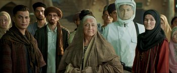 Movie still from “Pathaan” (2023), directed by Siddharth Anand – An old woman with a long veil and a group of people; Close Up shot, Low angle