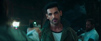 Movie still from “Pathaan” (2023), directed by Siddharth Anand – A person wearing a green jacket; Close Up shot, Over the shoulder angle