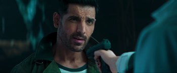 Movie still from “Pathaan” (2023), directed by Siddharth Anand – A man is holding a gun while another man holds a gun; Close Up shot, Over the shoulder angle