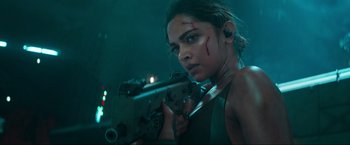 Movie still from “Pathaan” (2023), directed by Siddharth Anand – A woman holding a gun in a dark room; Close Up shot, Over the shoulder angle