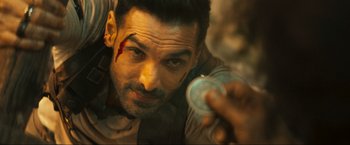 Movie still from “Pathaan” (2023), directed by Siddharth Anand – A person holding a coin; Close Up shot, Overhead angle