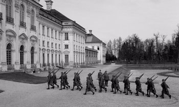 Movie still from “Paths of Glory” (1957), directed by Stanley Kubrick – A black and white photo of a group of soldiers marching down a street; Extreme Wide shot, High angle
