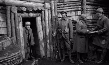 Movie still from “Paths of Glory” (1957), directed by Stanley Kubrick – A group of men standing in front of a wooden building; Wide shot, High angle