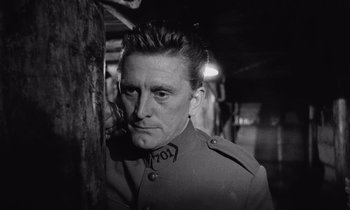 Movie still from “Paths of Glory” (1957), directed by Stanley Kubrick – A man in a military uniform standing next to a wooden pole; Close Up shot, Low angle