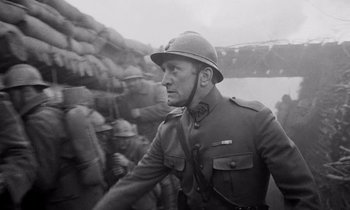 Movie still from “Paths of Glory” (1957), directed by Stanley Kubrick – An old photo of a man in a military uniform; Medium shot, Low angle