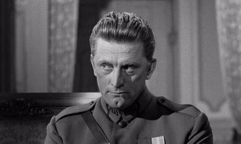 Movie still from “Paths of Glory” (1957), directed by Stanley Kubrick – A man in a military uniform looking at the camera; Close Up shot, Over the shoulder angle