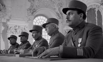 Movie still from “Paths of Glory” (1957), directed by Stanley Kubrick – A black and white photo of a group of men in uniform; Medium shot, Low angle