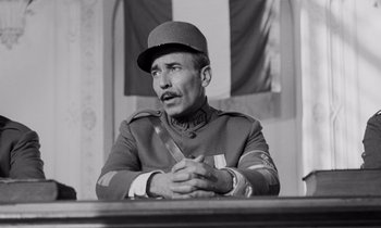 Movie still from “Paths of Glory” (1957), directed by Stanley Kubrick – An old photo of a man in a uniform sitting at a table; Close Up shot, Low angle