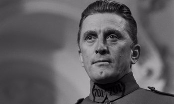 Movie still from “Paths of Glory” (1957), directed by Stanley Kubrick – A man in a military uniform is looking into the distance; Close Up shot, Low angle