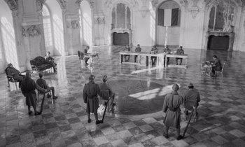 Movie still from “Paths of Glory” (1957), directed by Stanley Kubrick – A group of men standing around a room; Wide shot, High angle