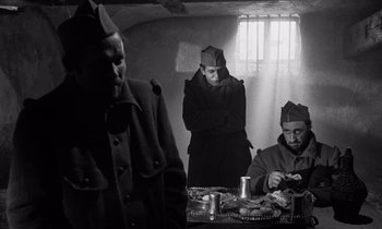 Movie still from “Paths of Glory” (1957), directed by Stanley Kubrick – A group of people sitting at a table; Medium shot, Low angle