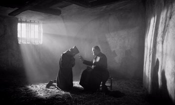 Movie still from “Paths of Glory” (1957), directed by Stanley Kubrick – Two people sitting in a room in a cave; Wide shot, Low angle