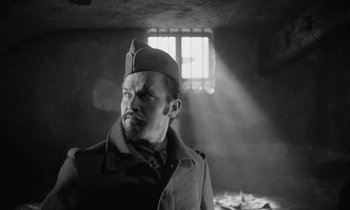 Movie still from “Paths of Glory” (1957), directed by Stanley Kubrick – A black and white photo of a man wearing a hat; Medium shot, Low angle