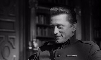 Movie still from “Paths of Glory” (1957), directed by Stanley Kubrick – A man in a military uniform looking to his left; Close Up shot, Over the shoulder angle