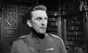 Movie still from “Paths of Glory” (1957), directed by Stanley Kubrick – A man wearing a uniform in a library; Close Up shot, Low angle