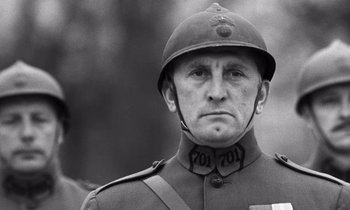 Movie still from “Paths of Glory” (1957), directed by Stanley Kubrick – A man in a military uniform wearing a helmet; Close Up shot, Low angle