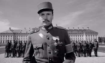 Movie still from “Paths of Glory” (1957), directed by Stanley Kubrick – A man in a military uniform standing in front of a group of soldiers; Medium shot, Low angle