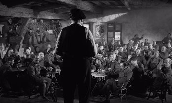 Movie still from “Paths of Glory” (1957), directed by Stanley Kubrick – An old photo of a man giving a speech to a crowd; Wide shot, Over the shoulder angle