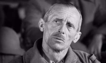 Movie still from “Paths of Glory” (1957), directed by Stanley Kubrick – An old man with a mustache and a beard looking at the camera; Close Up shot, High angle