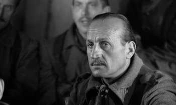 Movie still from “Paths of Glory” (1957), directed by Stanley Kubrick – A black and white photo of a man with a mustache; Close Up shot, Over the shoulder angle