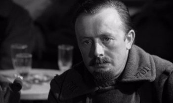 Movie still from “Paths of Glory” (1957), directed by Stanley Kubrick – A black and white photo of a man with a beard; Close Up shot, Over the shoulder angle