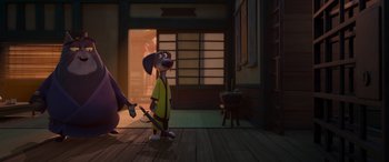 Movie still from “Paws of Fury: The Legend of Hank” (2022), directed by Chris Bailey – A dog wearing a yellow shirt standing next to another dog; Wide shot, Low angle