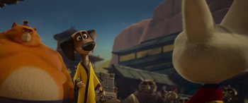 Movie still from “Paws of Fury: The Legend of Hank” (2022), directed by Chris Bailey – A cartoon dog wearing a yellow robe standing in front of a group of cats; Wide shot, Low angle