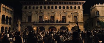 Movie still from “Perfume: The Story of a Murderer” (2006), directed by Tom Tykwer – A crowd of people standing outside of a building at night; Extreme Wide shot, Low angle