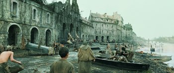 Movie still from “Perfume: The Story of a Murderer” (2006), directed by Tom Tykwer – A group of people standing in front of a building; Extreme Wide shot, High angle