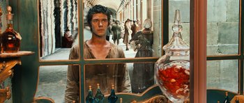 Movie still from “Perfume: The Story of a Murderer” (2006), directed by Tom Tykwer – A man standing in front of a store window; Medium shot, Over the shoulder angle