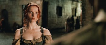Movie still from “Perfume: The Story of a Murderer” (2006), directed by Tom Tykwer – A woman with long red hair standing in front of a brick wall; Close Up shot, Over the shoulder angle