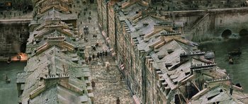 Movie still from “Perfume: The Story of a Murderer” (2006), directed by Tom Tykwer – An aerial view of an old town with people walking down the street; Extreme Wide shot, High angle