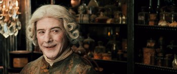 Movie still from “Perfume: The Story of a Murderer” (2006), directed by Tom Tykwer – An old man with blonde curly hair and a smile on his face; Close Up shot, Over the shoulder angle