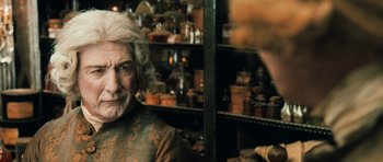 Movie still from “Perfume: The Story of a Murderer” (2006), directed by Tom Tykwer – An old man with a long white hair in a room full of jars; Close Up shot, Over the shoulder angle