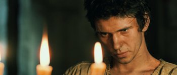 Movie still from “Perfume: The Story of a Murderer” (2006), directed by Tom Tykwer – A person holding a lit candle; Close Up shot, Low angle