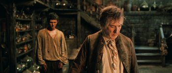 Movie still from “Perfume: The Story of a Murderer” (2006), directed by Tom Tykwer – A man and a woman standing next to each other in a room; Medium shot, Over the shoulder angle