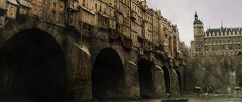 Movie still from “Perfume: The Story of a Murderer” (2006), directed by Tom Tykwer – An image of a building that is on the side of a bridge; Extreme Wide shot, Low angle