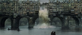Movie still from “Perfume: The Story of a Murderer” (2006), directed by Tom Tykwer – Smoke billows out of a body of water near buildings; Extreme Wide shot, High angle