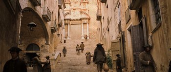 Movie still from “Perfume: The Story of a Murderer” (2006), directed by Tom Tykwer – A group of people walking down a set of stairs; Extreme Wide shot, High angle