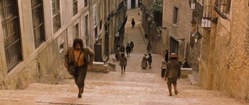 Movie still from “Perfume: The Story of a Murderer” (2006), directed by Tom Tykwer – A group of people walking down the side of a street; Extreme Wide shot, High angle