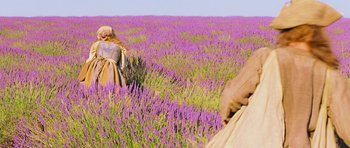 Movie still from “Perfume: The Story of a Murderer” (2006), directed by Tom Tykwer – Two people in a field of purple flowers; Wide shot, Low angle