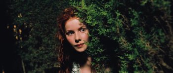 Movie still from “Perfume: The Story of a Murderer” (2006), directed by Tom Tykwer – A beautiful woman with red hair standing in the bushes; Close Up shot, High angle